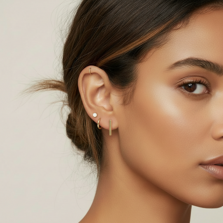 A pair of 14k yellow gold bar style stud earrings with friction backs, presented against a white background.
