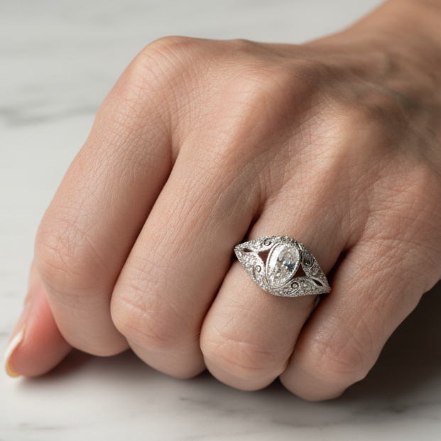 Close-up of a hand wearing a Platinum ring with a diamond on a light background
